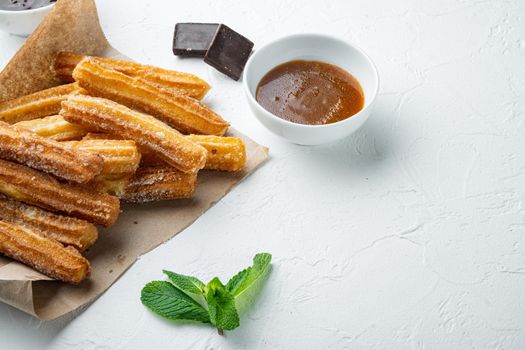 Traditional Spanish dessert churros with sugar and chocolate set, on white background with space for text, copyspace