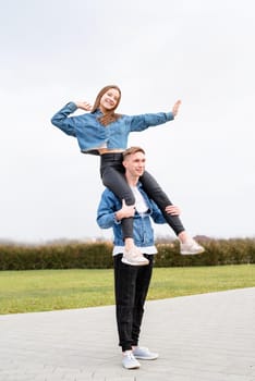 Young loving couple wearing jeans spending time together in the park having fun