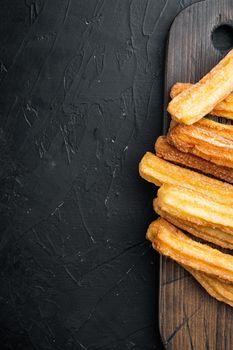 Churros with caramel, Traditional Spanish cusine, on black background, top view flat lay with space for text, copyspace