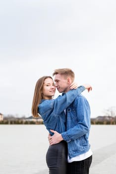 Happy young loving couple embracing each other outdoors in the park having fun