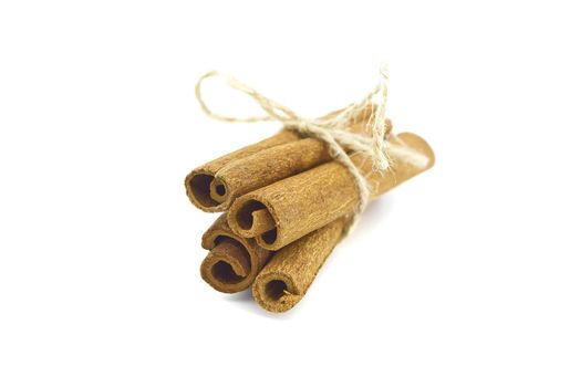 Cinnamon sticks bundle tied with jute string isolated on white background