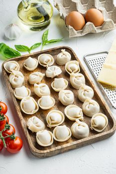 Tortellini with Parmesan and Basil set in wooden tray, on white background