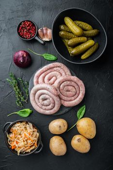 Fried Bavarian German Nurnberger sausages with sauerkraut, mashed potatoe, on black background, top view flat lay