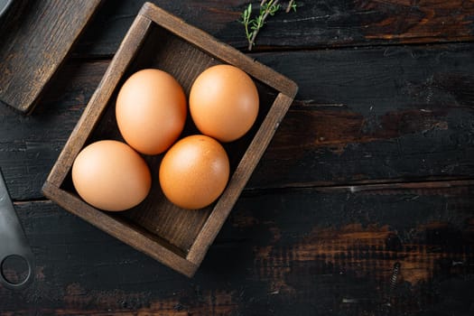 Raw chicken eggs in egg box set, on old dark wooden table background, top view flat lay , with space for text copyspace