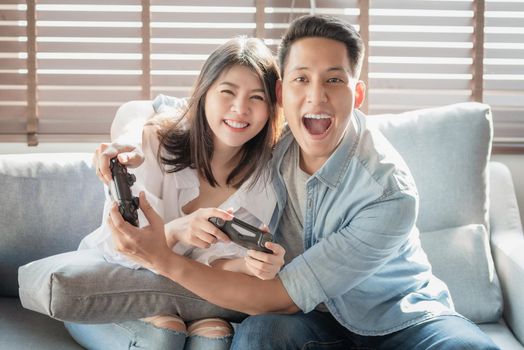 Asian couple lovers enjoy and play console game on vacation make more quality time of happiness together at home