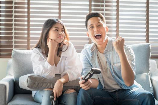 Asian couple lovers enjoy and play console game on vacation make more quality time of happiness together at home