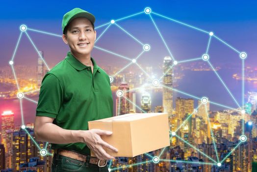 Asian delivery man or passenger holding a cardboard box with global positioning system with smart city in background