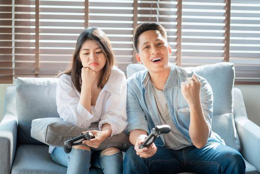 Asian couple lovers enjoy and play console game on vacation make more quality time of happiness together at home