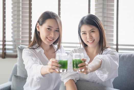 Two beautiful woman enjoy drinking healthy drink during stay safe at home