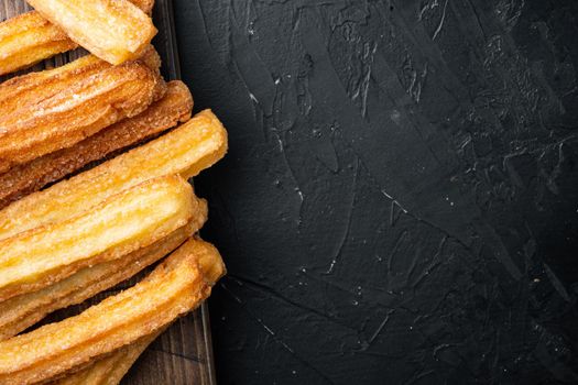 Churros with chocolate, Traditional Spanish cusine, on black background, top view flat lay with space for text, copyspace