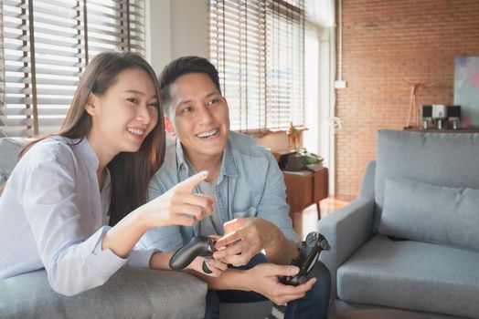 Asian couple lovers enjoy and play console game on vacation make more quality time of happiness together at home