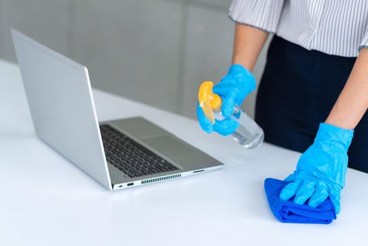 Business woman wearing mask and using personal sanitizer to cleaning her table in office to keep hygiene.Preventive during the period of epidemic from coronavirus or covid19.