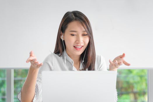 Business employee using laptop for video conferencing with colleagues via internet technology at home office.