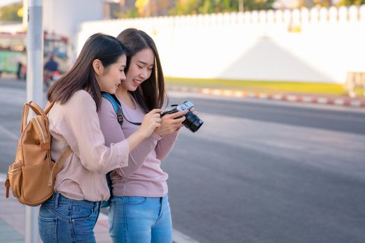 Beautiful asian tourists woman enjoy travel together and photograph landmark in urban city street on vacation