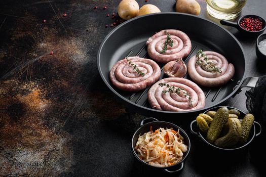 Traditional German Sausages with Mashed Potato and Sauerkraut in cast iron frying pan, on old dark rustic background, top view flat lay , with space for text copyspace