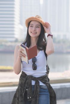 Beautiful asian solo tourist woman  smiling and searching for tourists sightseeing spot. Vacation travel in summer.
