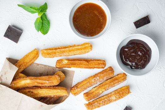Churros with sugar, and chocolate sauce, on white background, top view flat lay