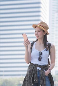 Beautiful asian tourist woman looking at mobile phone for searching tourists sightseeing spot. Vacation travel in summer