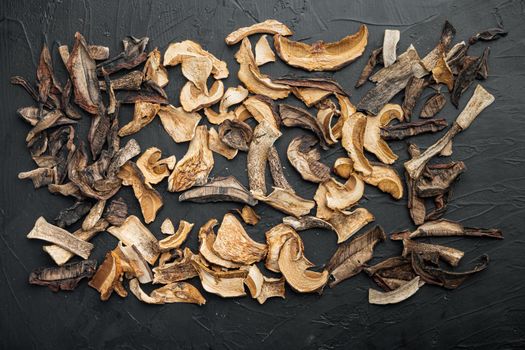 Dried mushrooms set, on black background, top view flat lay