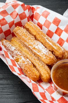 Churros take away set in paper tray, on black wooden table background