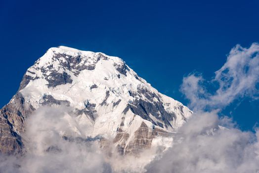 Annapurna South mountain peak with blue sky background in Nepal