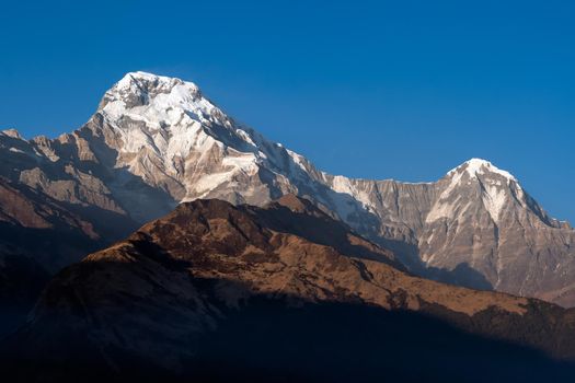 Annapurna South mountain peak with blue sky background in Nepal