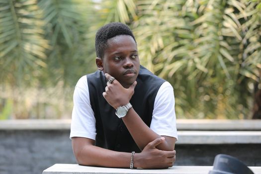 Portrait of young handsome afro black man posing outdoor.