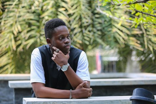 Portrait of young handsome afro black man posing outdoor.