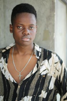 Portrait of young handsome afro black man posing outdoor.