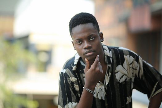 Portrait of young handsome afro black man posing outdoor.