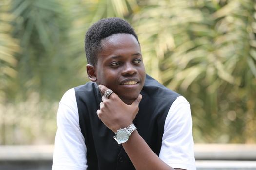 Portrait of young handsome afro black man posing outdoor.