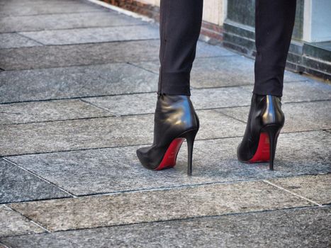 Close up view of woman legs wearing high-heeled shoes