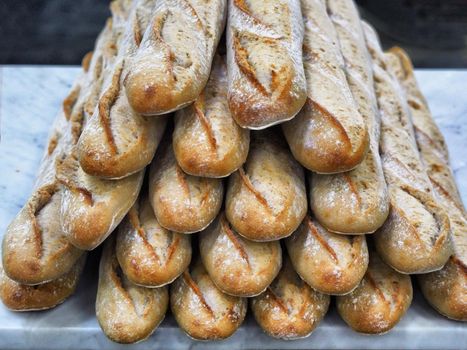 Freshly baked bread loaves stacked typical french baguette close up view