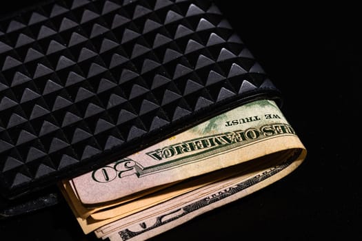 Dollars money banknotes in a black wallet isolated.