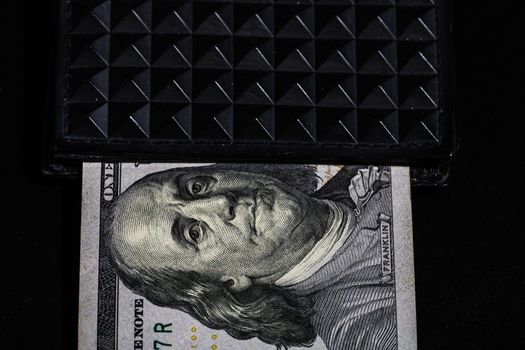 100 Dollars banknotes in a black wallet isolated
