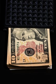 10 Dollars banknotes in a black wallet isolated