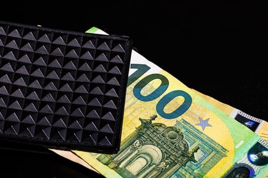 100 Euro money banknotes in black wallet isolated