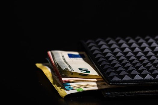 Euro banknotes in black wallet isolated.