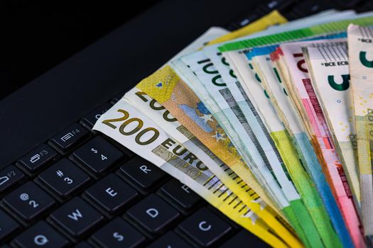 Euro  banknotes on keyboard. Selective focus on stack euro money.