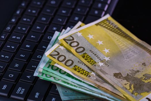 Euro  banknotes on keyboard. Selective focus on stack euro money.