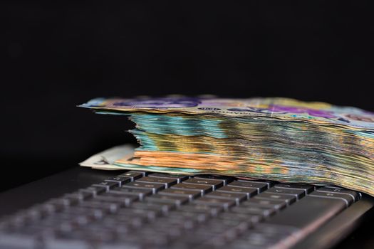 Lei banknotes on keyboard. Selective focus on stack of LEI romanian money.