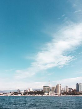 SOCHI, RUSSIA - March 24, 2020. View on embankment and apartment buildings from Black sea in sunny weather.