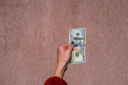 Hand holding showing dollars money and giving or receiving money like tips, salary. 100 USD banknotes, American Dollars currency isolated with copy space.