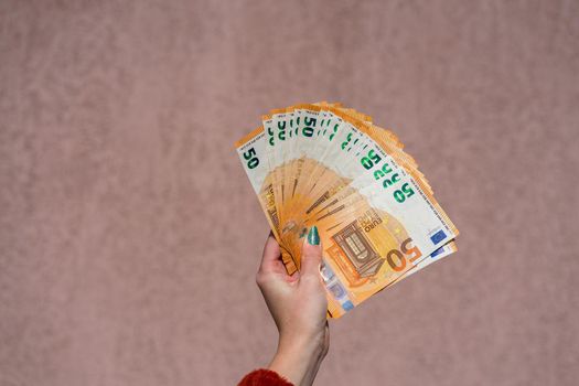 Hand holding and showing a fan of euro money or giving money. World money concept, 50 EURO banknotes EUR currency isolated. Concept of rich business people, saving or spending money.