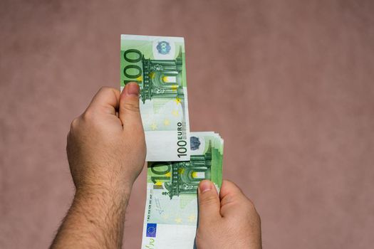 Hand holding and showing euro money or giving money. World money concept, 100 EURO banknotes EUR currency isolated. Concept of rich business people, saving or spending money.