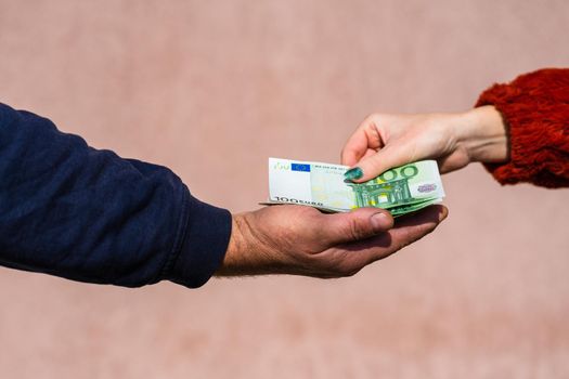 Hand giving money like bribe or tips or salary isolated, hard worked hand taking euro banknotes. Currency transfer and reward for hard work.