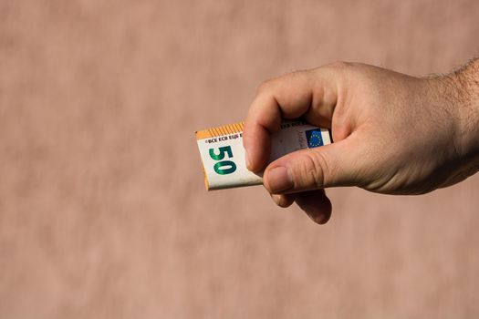 Man hands giving money like a bribe or tips. Holding EURO banknotes on a blurred background, EU currency