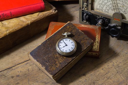 Reloj de bolsillo sobre libro antiguo mas objetos varios