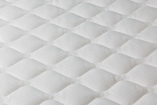 Soft white mattress close-up background with selective focus and blur.