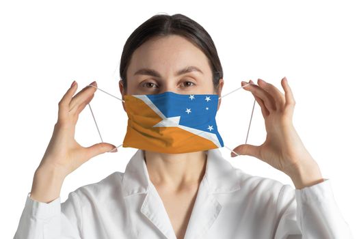 Respirator with flag of Argentine Antarctica. Doctor puts on medical face mask isolated on white background.